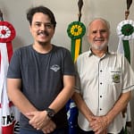 A imagem mostra dois homens em pé, lado a lado, posando para a foto em um ambiente interno institucional, possivelmente um gabinete público.