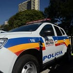 Carro de cor branca com adesivos da Polícia Militar.