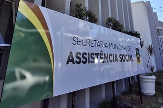 A imagem mostra a fachada de um prédio público, onde se destaca uma placa institucional com os dizeres “Secretaria Municipal de Assistência Social”.