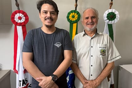 A imagem mostra dois homens em pé, lado a lado, posando para a foto em um ambiente interno institucional, possivelmente um gabinete público.