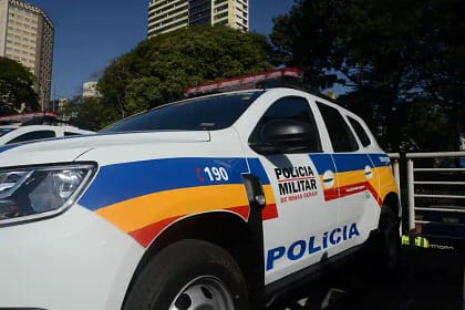 Carro de cor branca com adesivos da Polícia Militar.